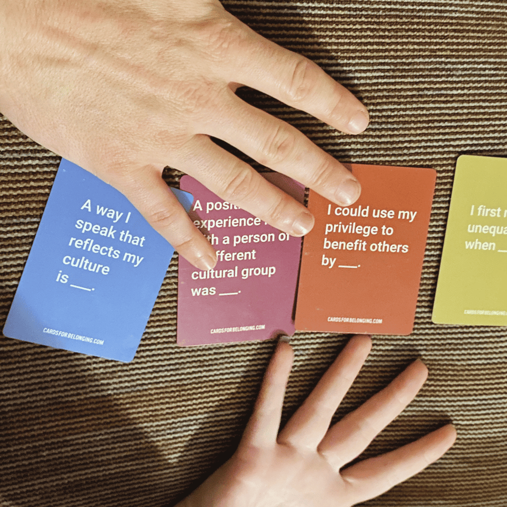 Hands holding question cards on a textured surface