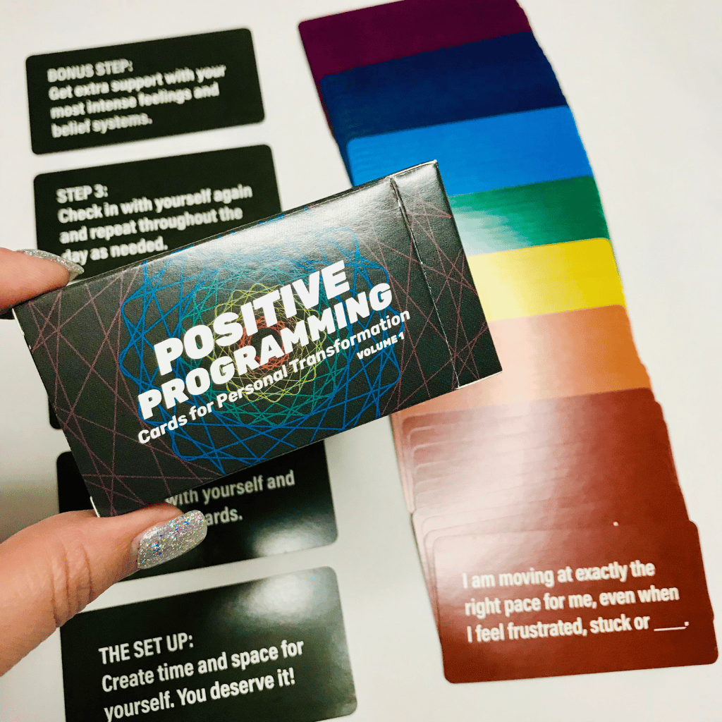 Positive Programming cards arranged in a rainbow fan with the deck box in the center.