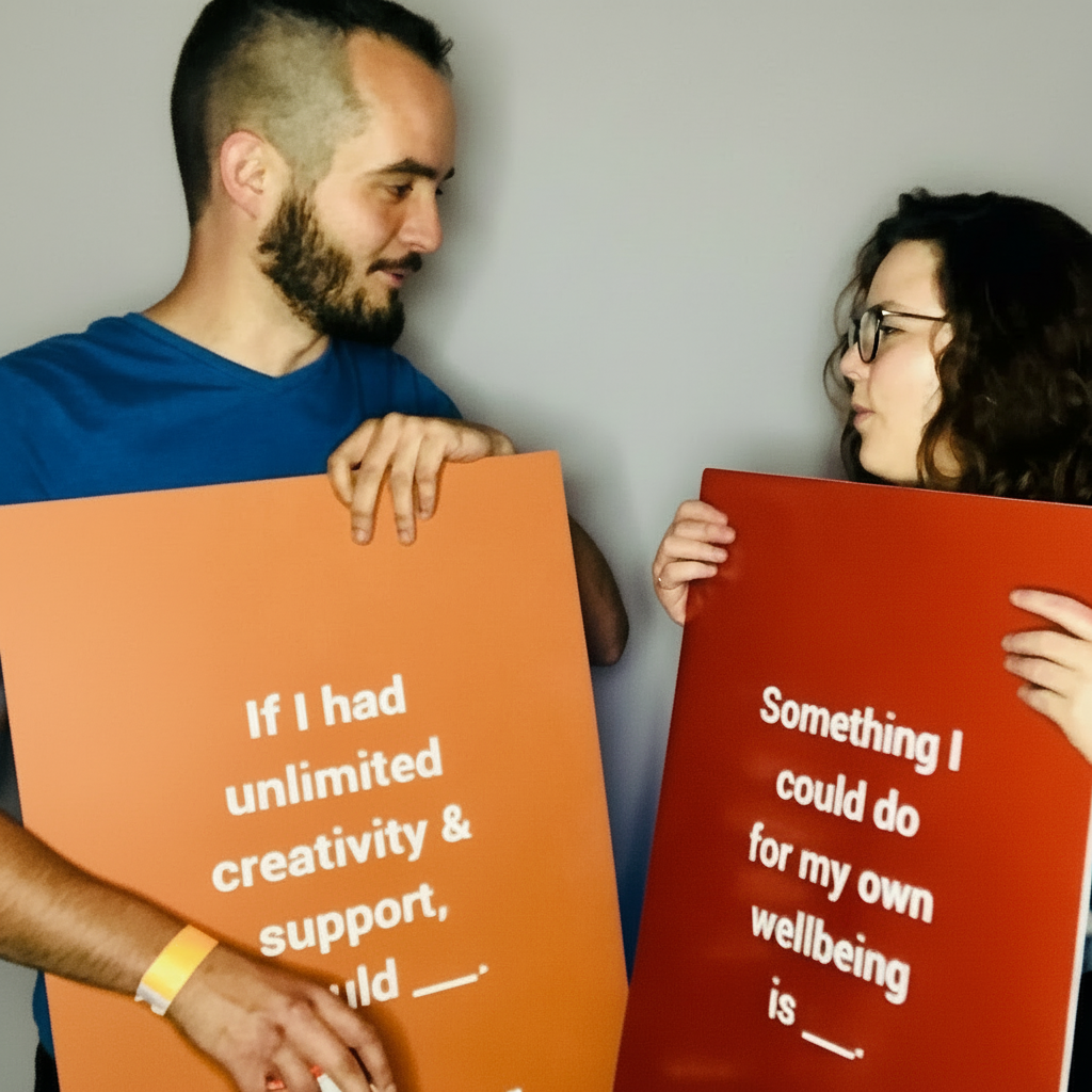 Two people holding signs with motivational text against a textured wall.