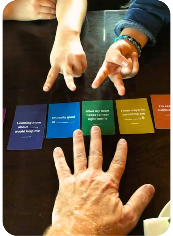 Kids and adult hands interacting with colorful cards for connection on a table