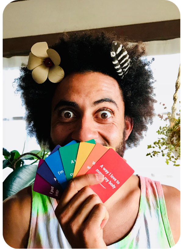 Wide-eyed person holding a spread of colorful conversation cards and smiling.