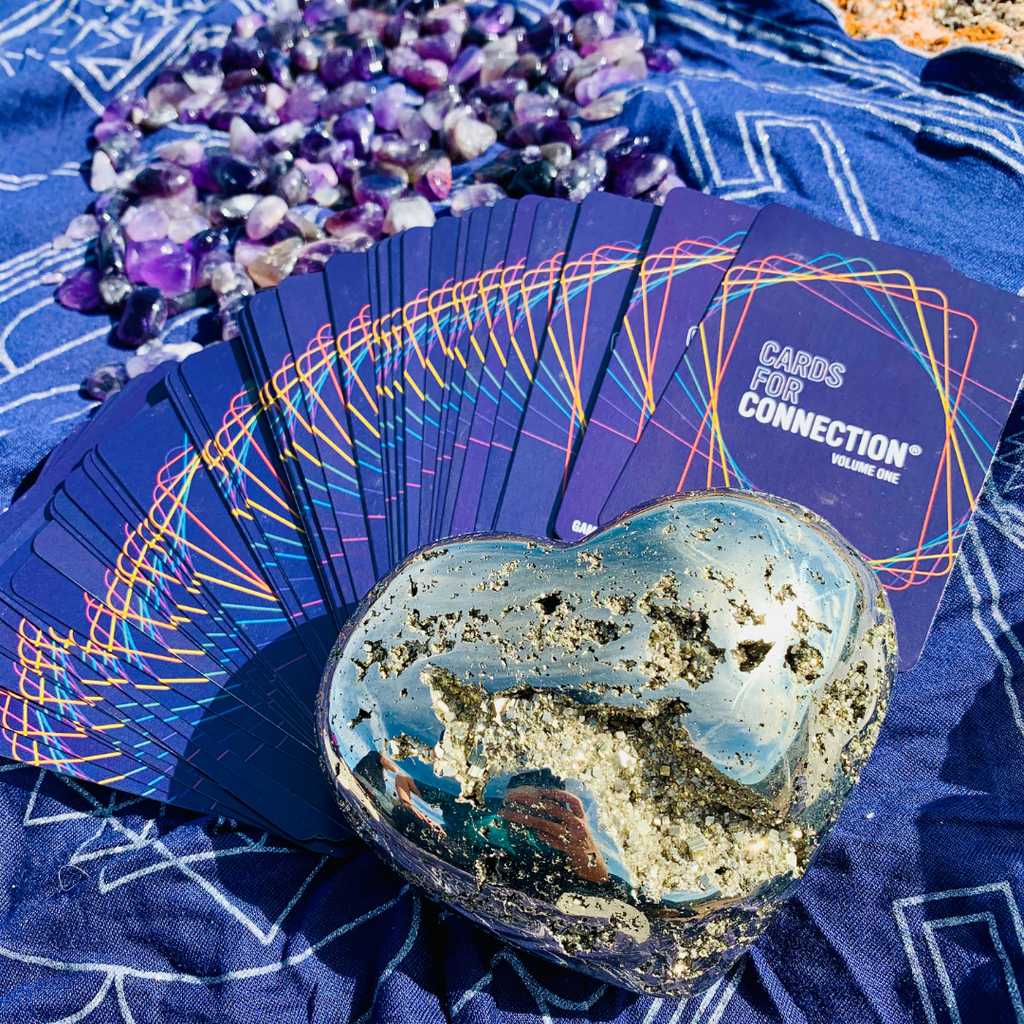 Set of cards for connection with a heart-shaped crystal on a blue cloth with crystals.