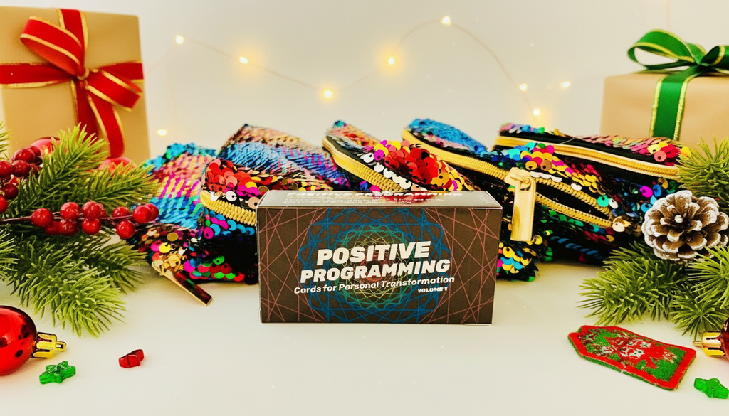 positive programming deck with sparkle sequin bags and holiday gifts on a white background