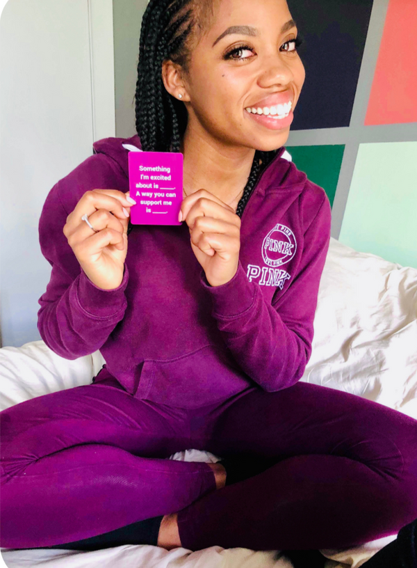Woman holding violet cards for connection "Something I'm excited about is ___. A way you can support me is ___."