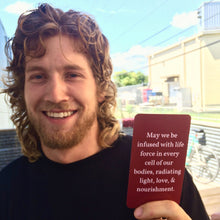 Load image into Gallery viewer, Infinite Blessings Deck - Games for Humanity Individual selecting a card from the Infinite Blessings Deck during a personal reflection session