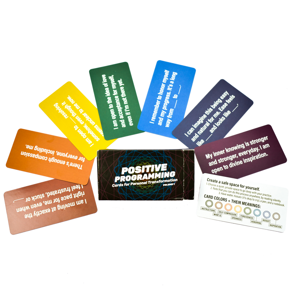 Close-up of the Positive Programming Deck cards spread out, showcasing colorful designs and affirmations. by games for humanity